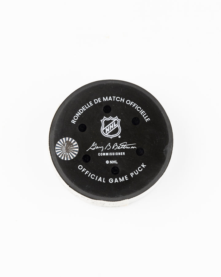 official Chicago Blackhawks game used hockey goal puck scored by player Nick Foligno against Montreal Canadiens on January 3, 2025 - back lay flat