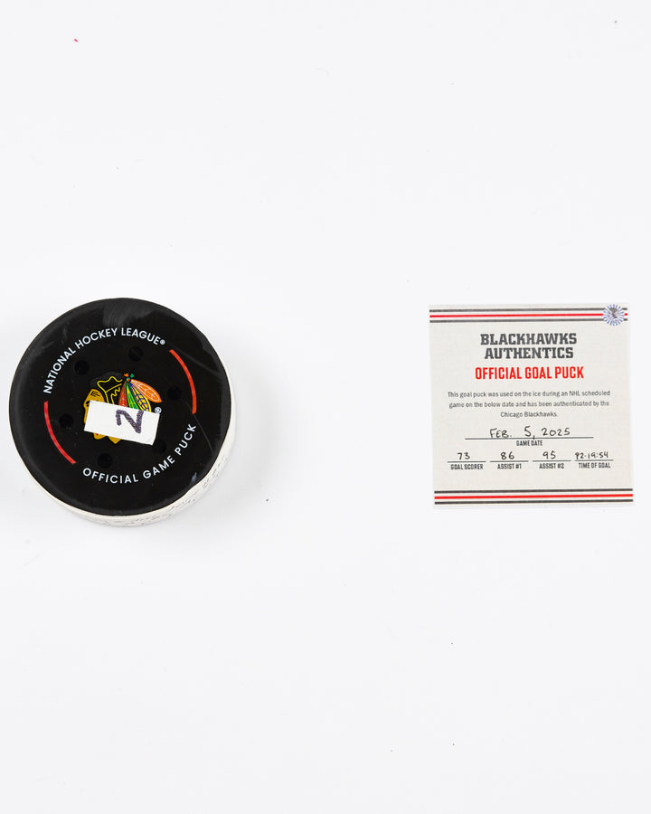 official Chicago Blackhawks game-used goal puck scored by Lukas Reichel on February 5, 2025 - front lay flat of puck and certificate