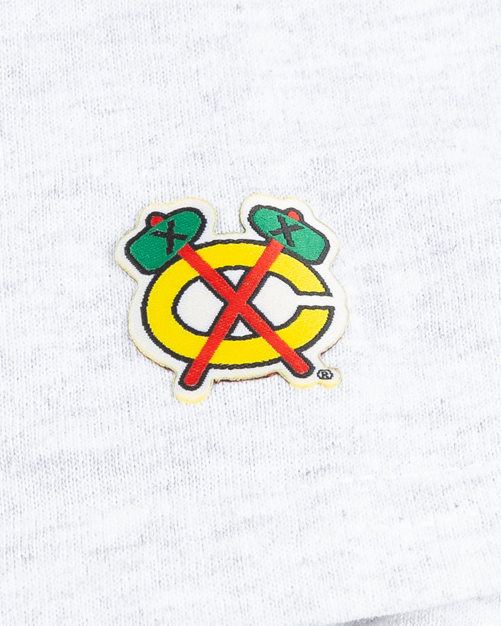 grey Chicago Blackhawks short sleeve tee with wordmark and primary logo on chest and secondary logo on left shoulder - detail shoulder  lay flat