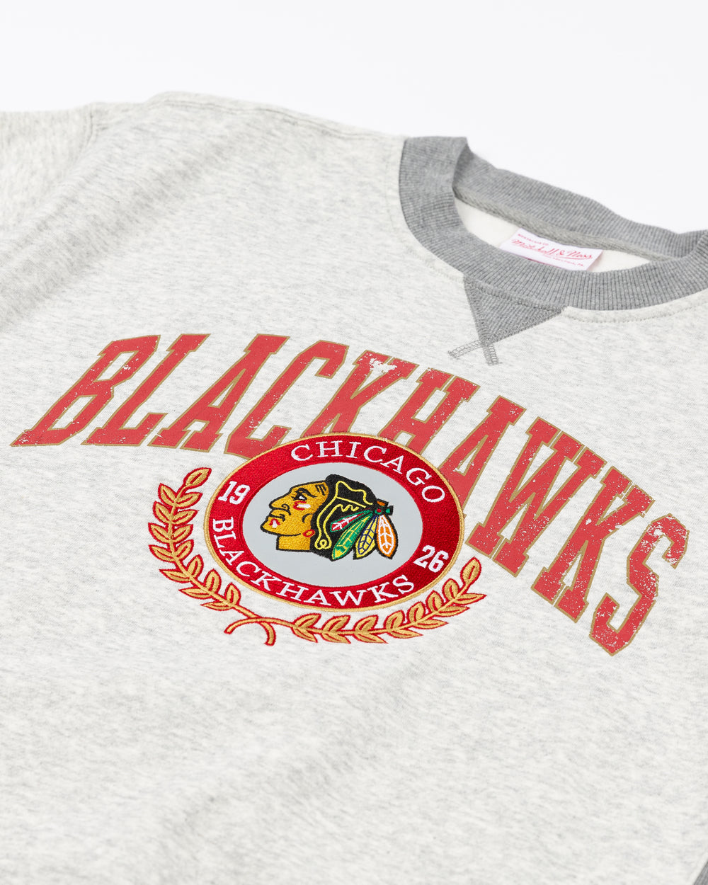 grey Mitchell & Ness crewneck with Chicago Blackhawks collegiate-inspired wordmark and primary logo on front - front detail lay flat