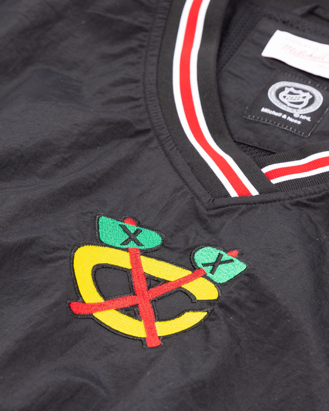 black Mitchell &amp; Ness pullover windbreaker with Chicago Blackhawks secondary logo on front and primary logo on right shoulder and NHL Western Conference on left cuff - front detail lay flat