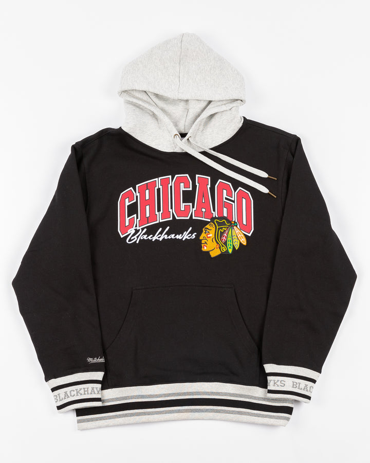 two tone black and grey Mitchell &amp; Ness hoodie with Chicago Blackhawks wordmark and primary logo on front - front lay flat