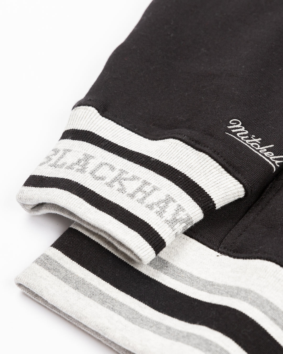 two tone black and grey Mitchell &amp; Ness hoodie with Chicago Blackhawks wordmark and primary logo on front - cuff detail lay flat