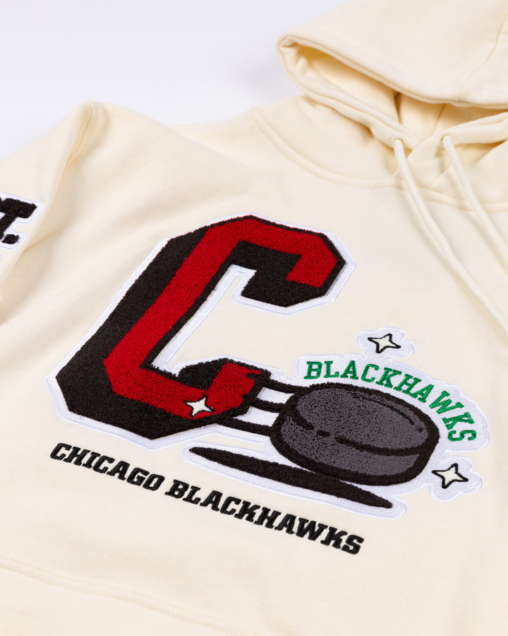 cream Mitchell &amp; Ness hoodie with Chicago Blackhawks C and puck graphic embroidered on front with est. 1926 embroidered on right sleeve and secondary logo on left sleeve - front detail lay flat