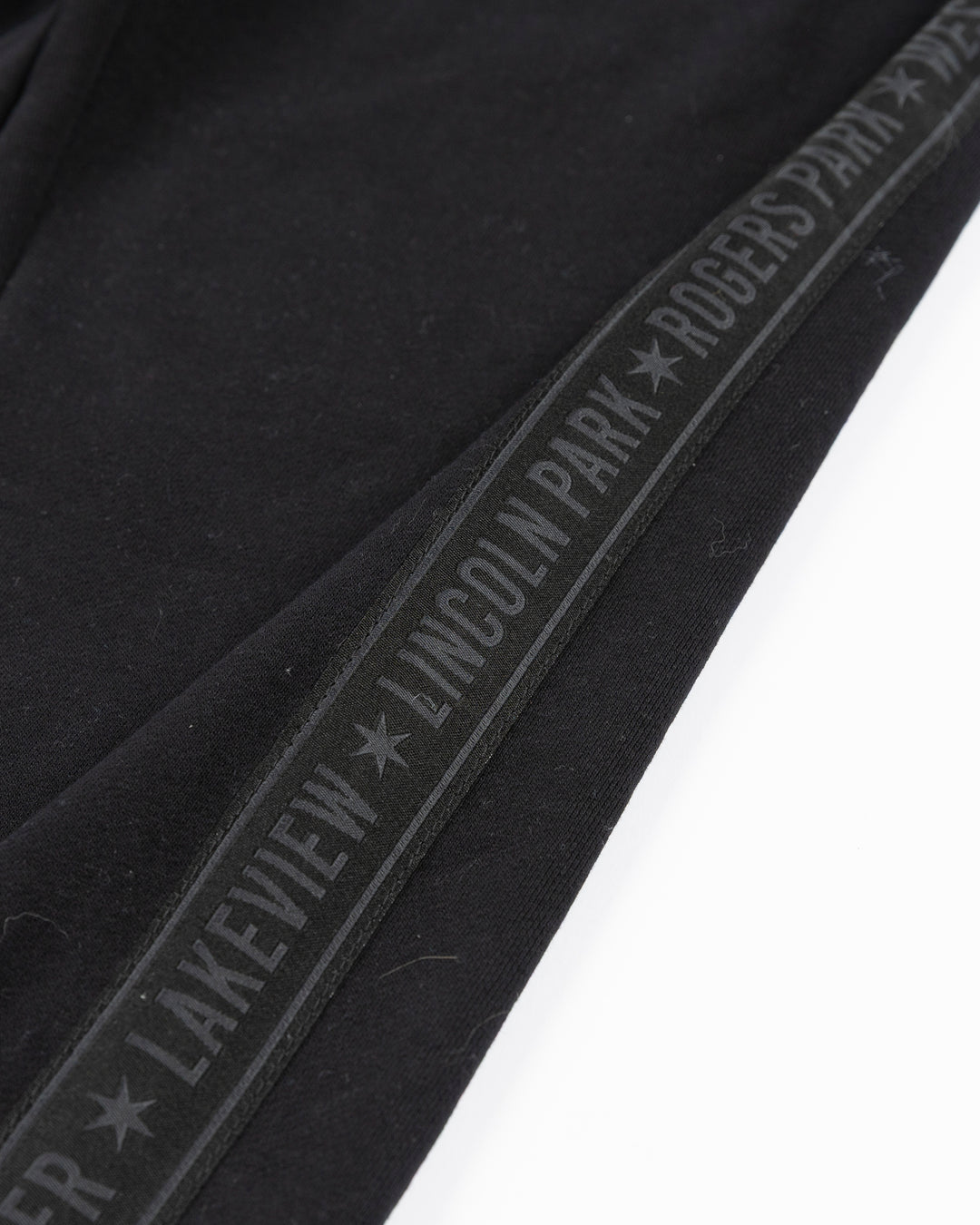 black sweatpants with Chicago Blackhawks secondary logo embroidered in Chicago flag colorway on left thigh and Chicago neighborhood names down sides - detail lay flat
