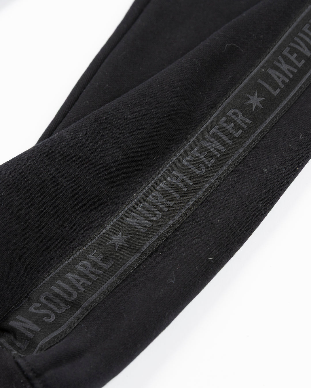 black sweatpants with Chicago Blackhawks secondary logo embroidered in Chicago flag colorway on left thigh and Chicago neighborhood names down sides - alt detail lay flat