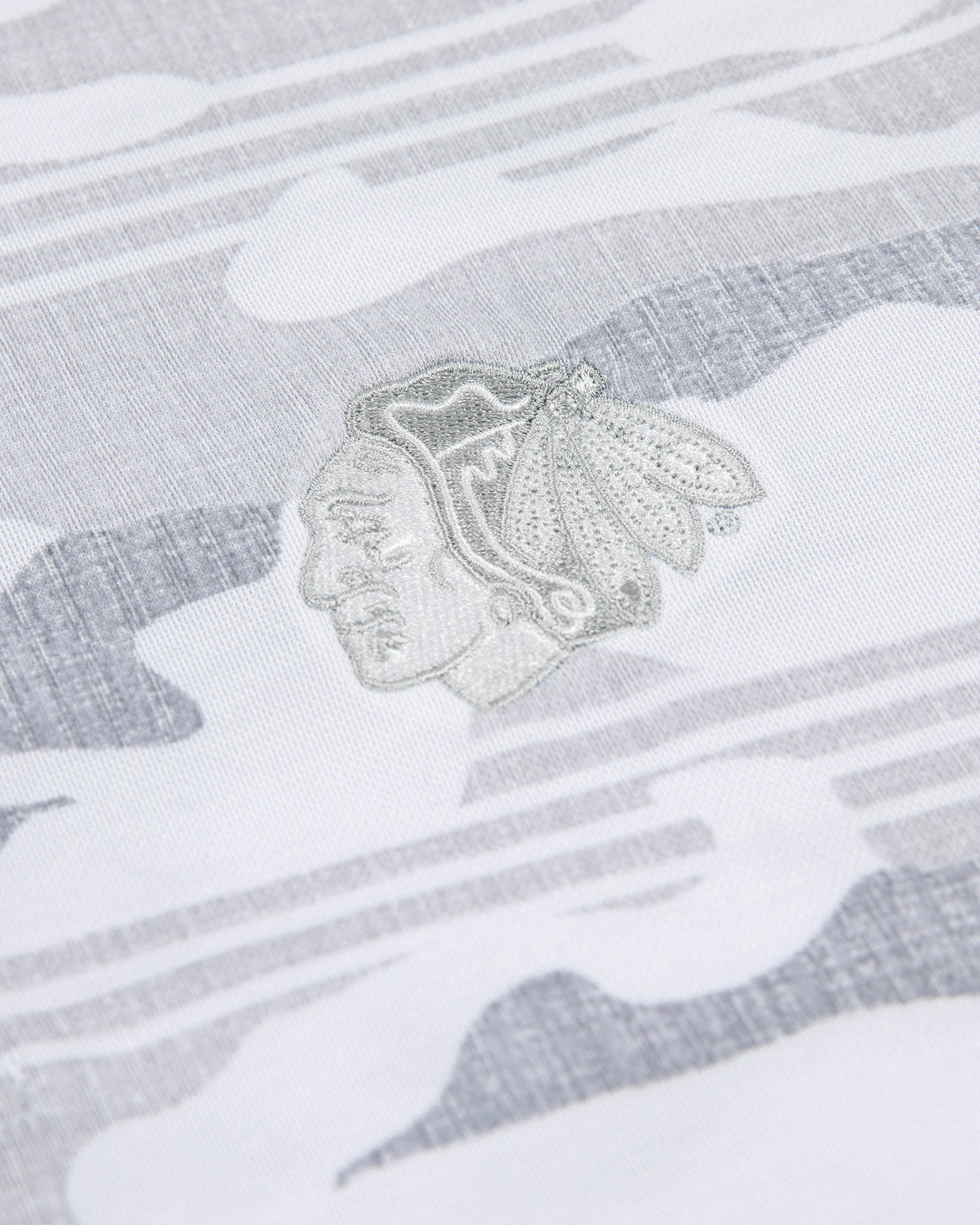 white camo TravisMathew polo with Chicago Blackhawks primary logo embroidered on left chest - detail lay flat